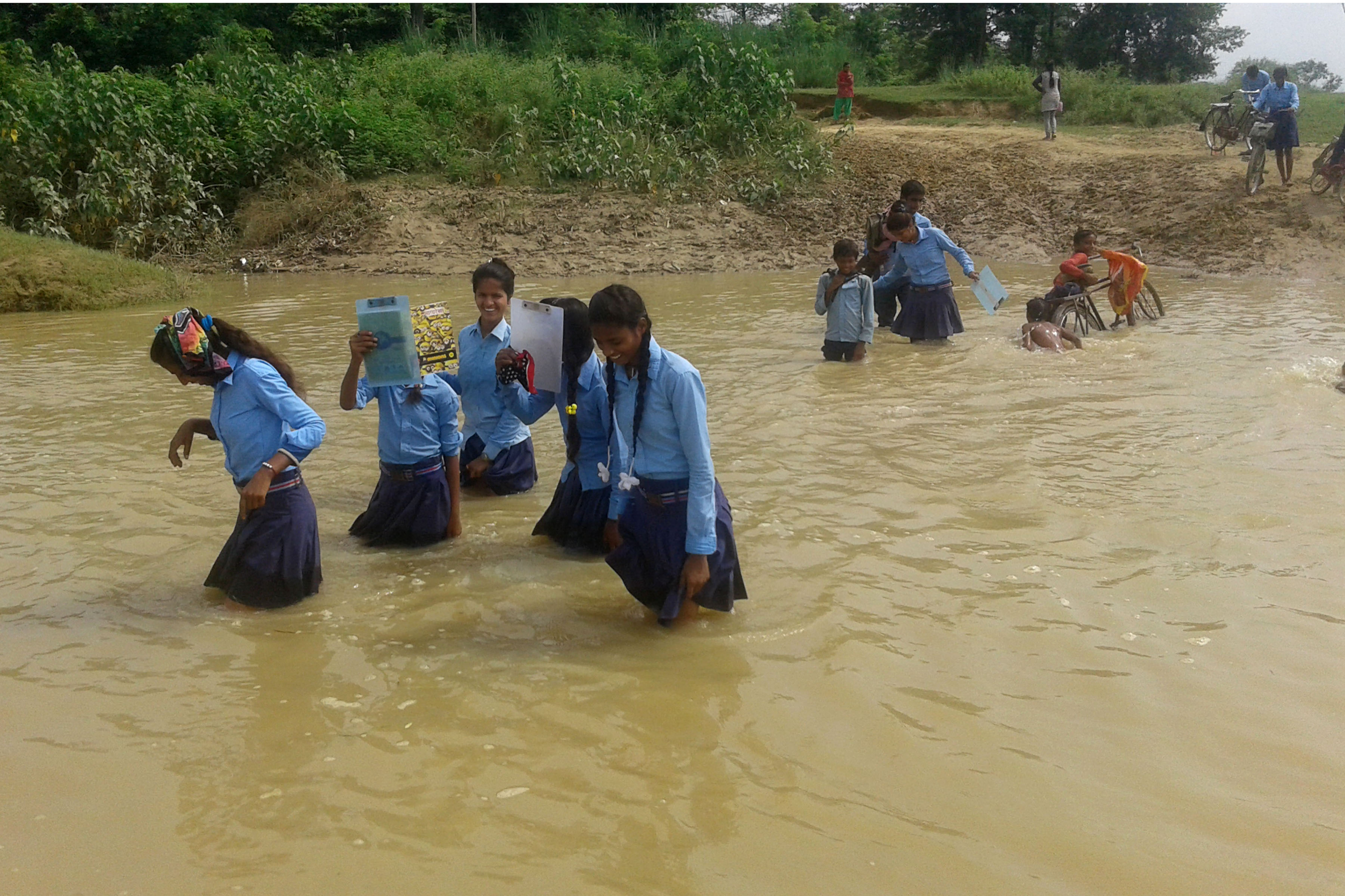 बाढी तरेर स्कुल जाँदै विद्यार्थी