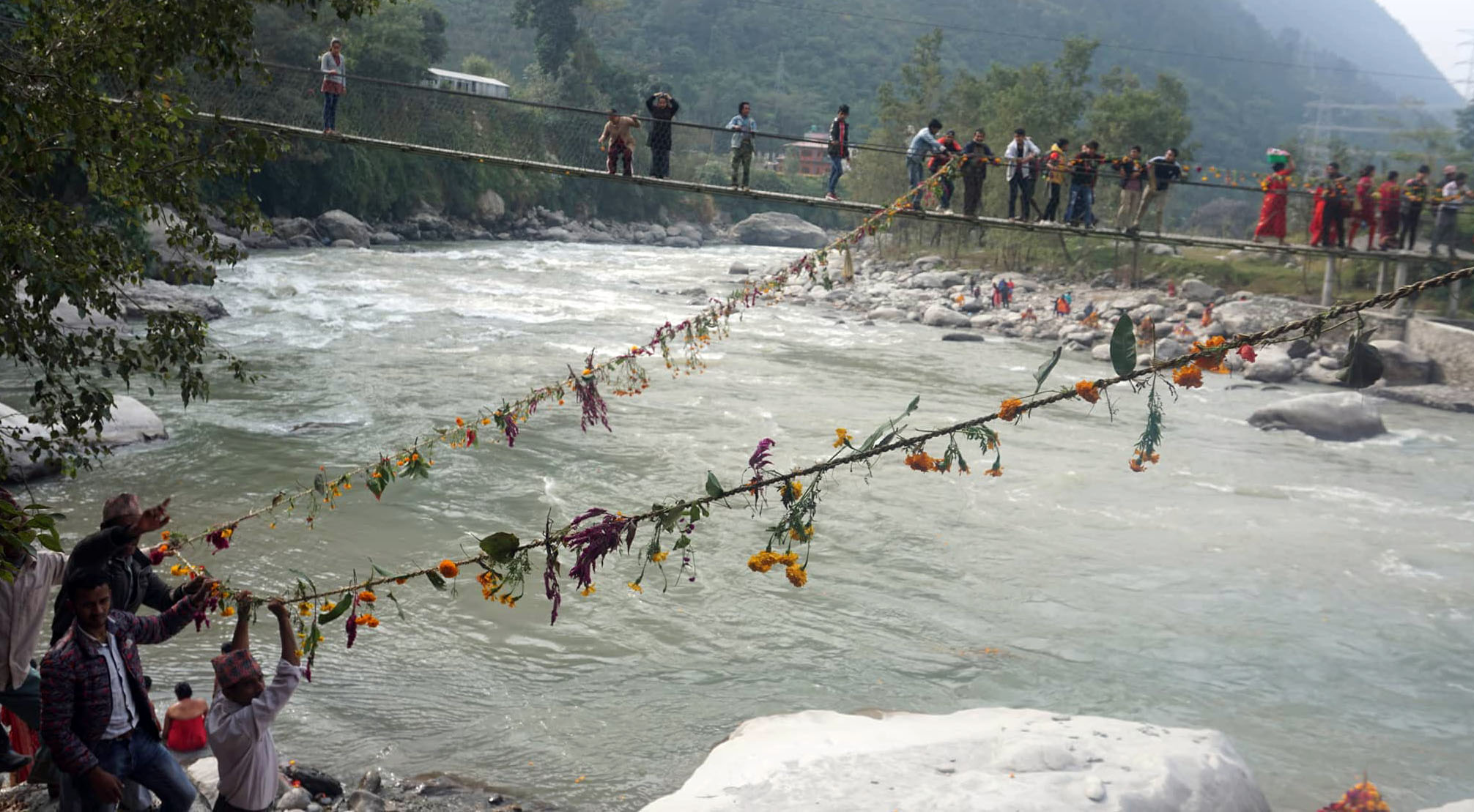त्रिशुली नदीमा फूलको तोरन तार्दै